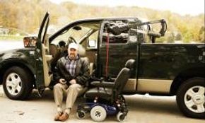 Individual sitting by modified vehicle with wheelchair