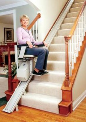 Woman using a stairlift at home