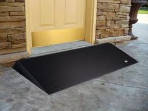 Black ramp at a yellow door entrance.