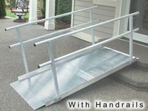 Aluminum ramp with handrails outside a building.