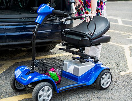 Person closing car trunk with scooter