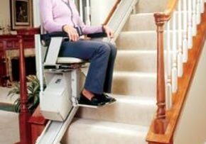 Woman using a stairlift at home